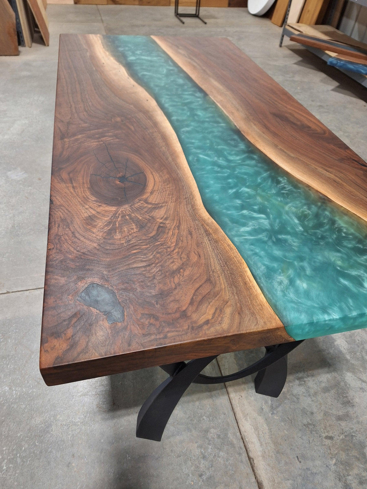 Solid walnut river dining table with green epoxy river and black metal legs, photographed in our Hiawatha shop (photo 2)