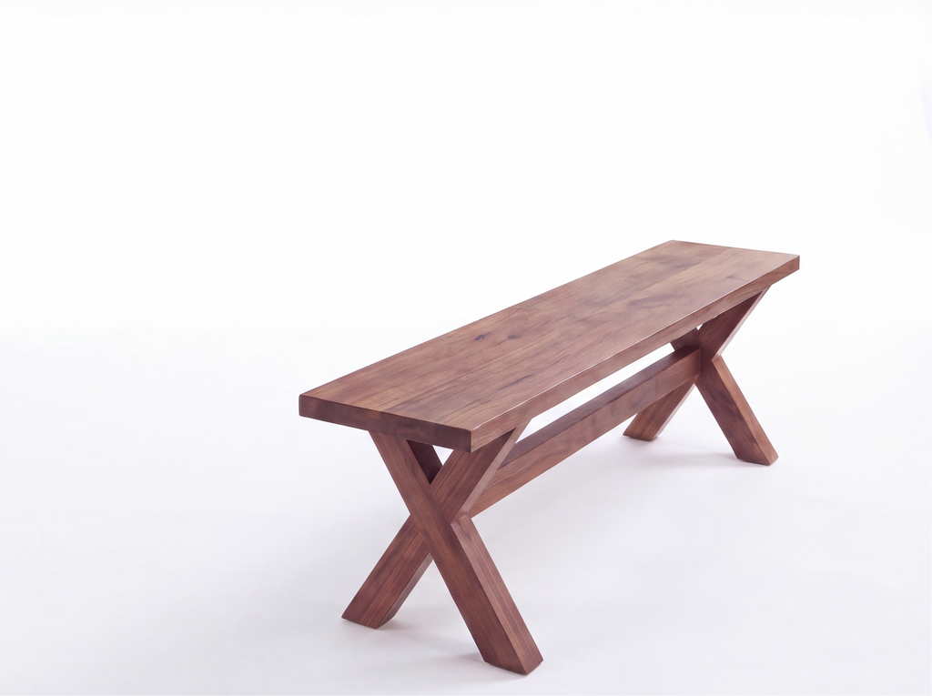 A rustic wooden bench with a dark brown finish and an X-shaped cross base, positioned on the right side of a clean white studio background.