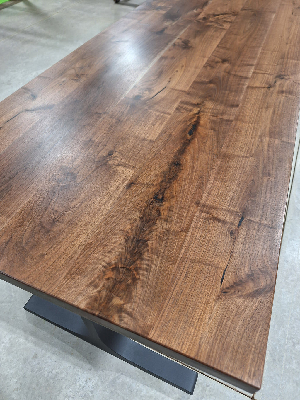 Solid walnut dining table top grain, angled view, in our shop
