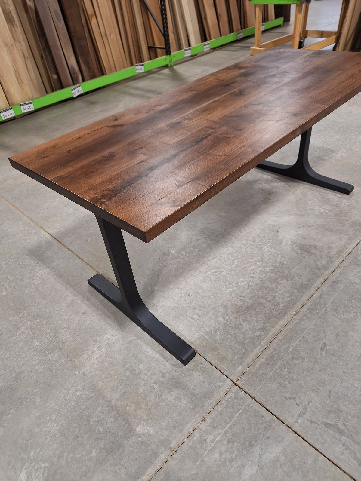 Solid walnut dining table with black metal legs in our Hiawatha, Iowa shop