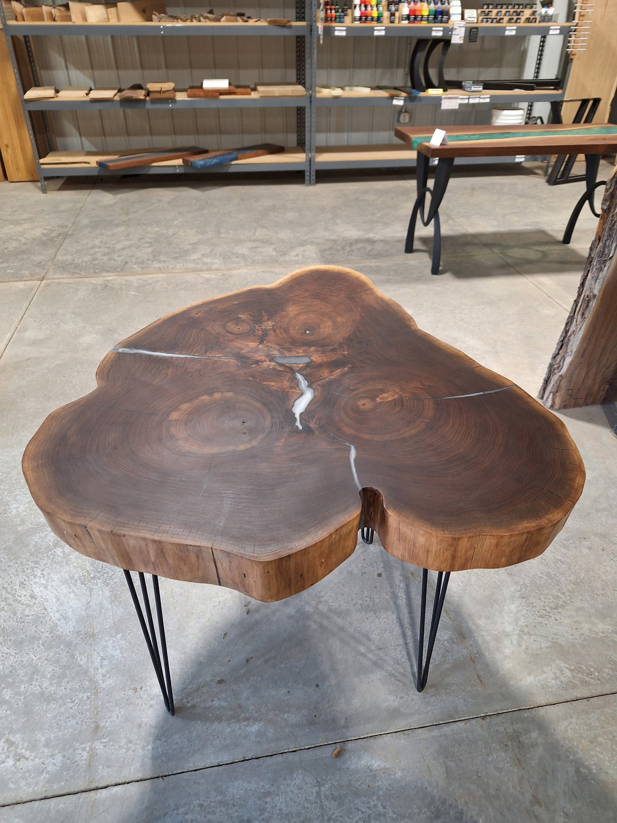 Solid walnut live edge cookie table with white epoxy inlay and black hairpin legs, photographed in our Hiawatha shop (photo 1)