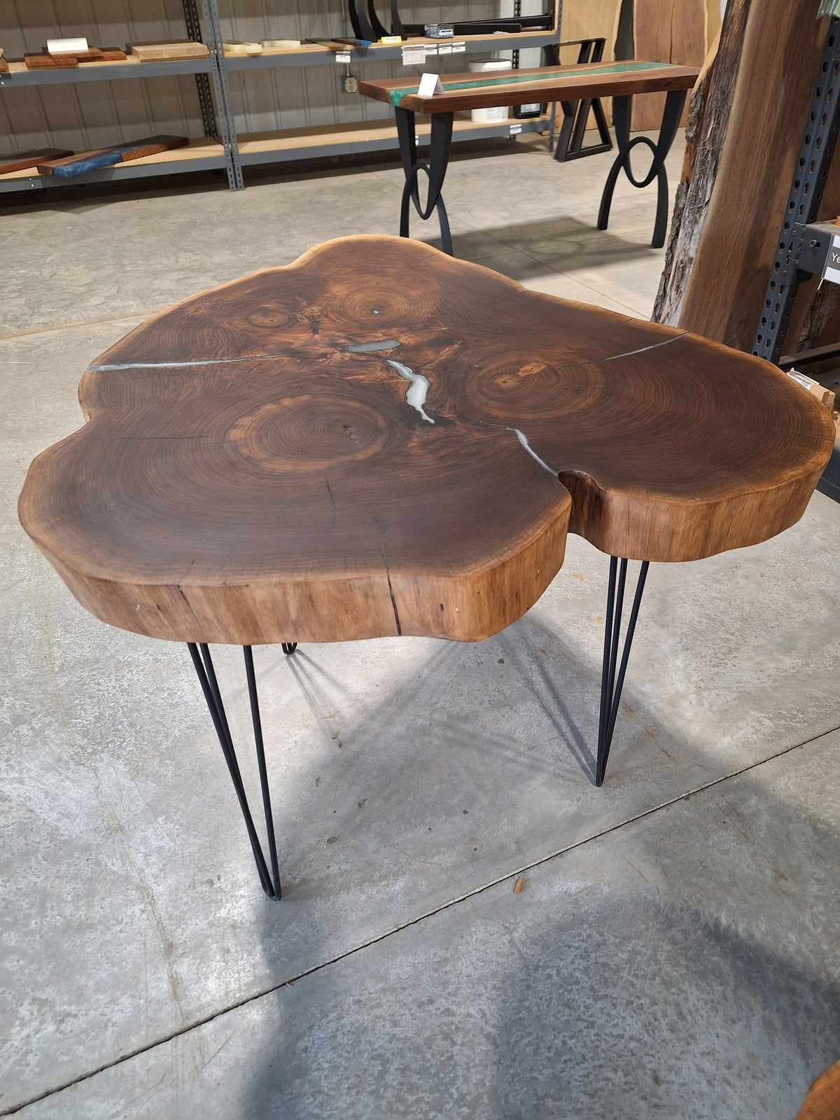 Solid walnut live edge cookie table with white epoxy inlay and black hairpin legs, photographed in our Hiawatha shop (photo 2)