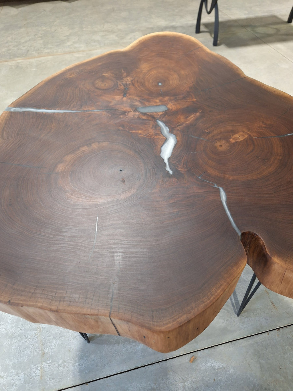 Solid walnut live edge cookie table with white epoxy inlay and black hairpin legs, photographed in our Hiawatha shop (photo 3)