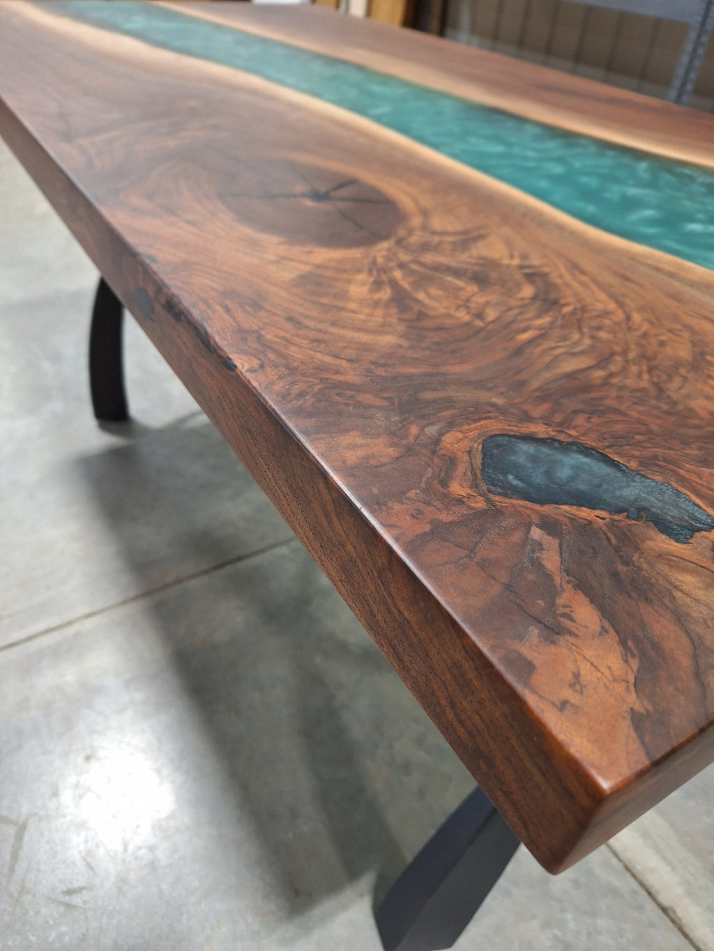 Solid walnut river dining table with green epoxy river and black metal legs, photographed in our Hiawatha shop (photo 8)